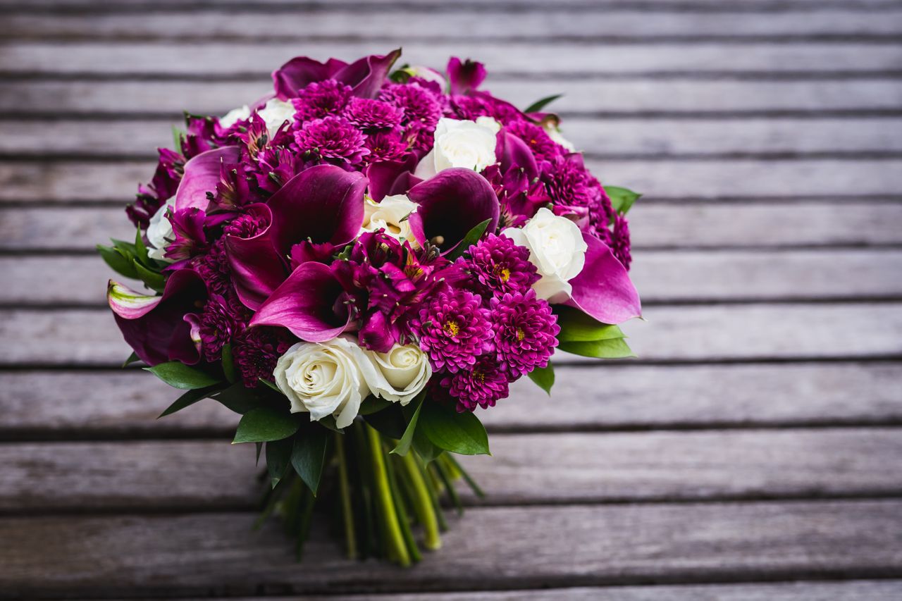 Beautiful bouquet of purple and white flowers on wooden background.